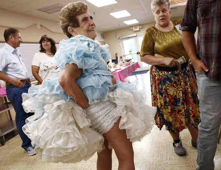 Faye and Ed Laudenschlager celebrated their 40th anniversary at the Pickerington Senior Center  with square dancing, much like their wedding day four decades ago. Faye, wearing a square dancing dress, shows off her panties to guests.   (Fred Squillante / The Columbus Dispatch)